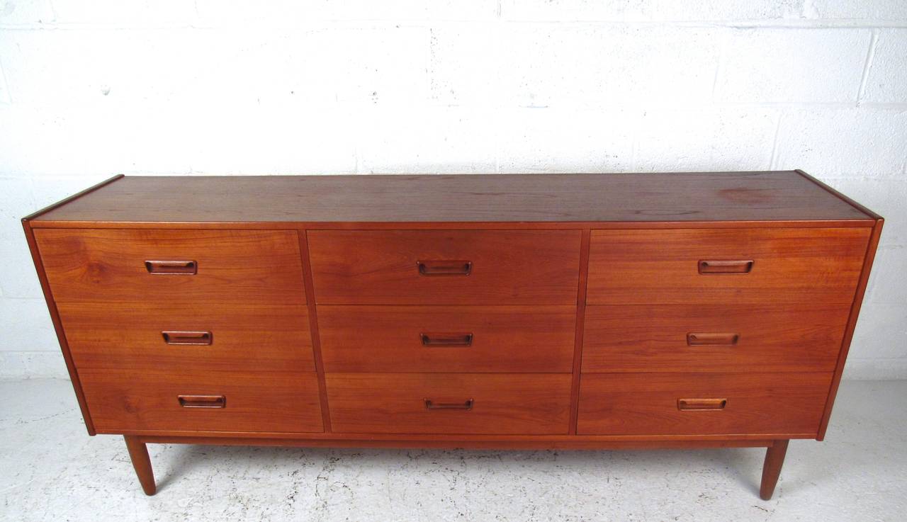 This vintage Danish dresser boasts a beautiful teak finish, dovetail joints, and tapered legs. Plenty of space for storage in any setting, this vintage dresser is a stylish and practical addition to any home. Please confirm item location (NY or NJ).