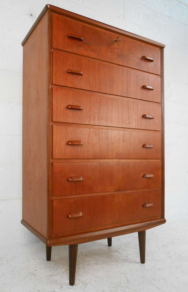 Teak chest of drawers with splayed/tapered legs and felt lined top drawer. Please confirm item location (NY or NJ) with dealer.