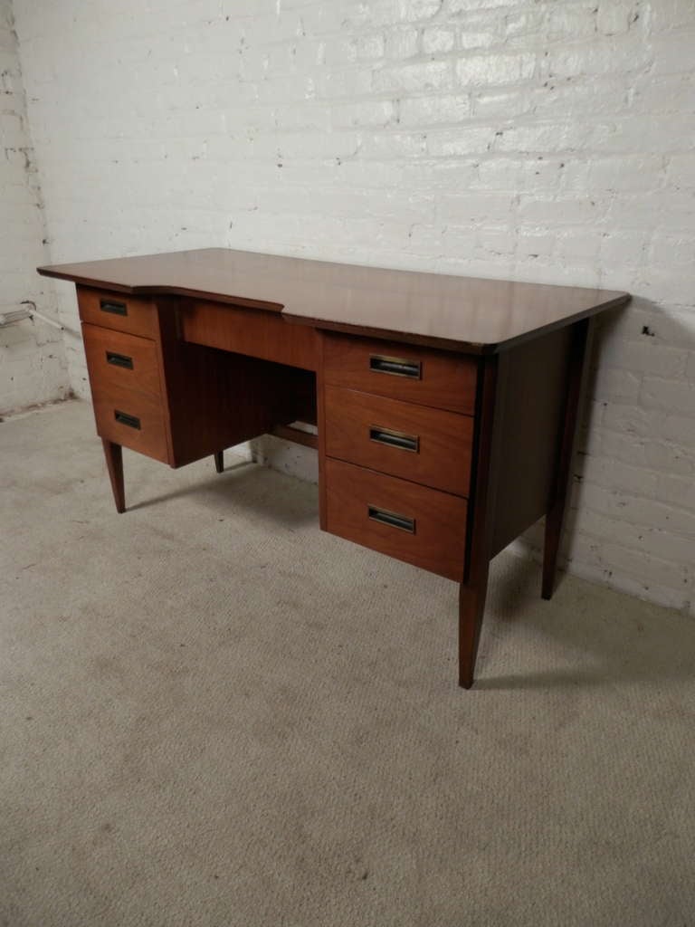 Mid-century walnut desk with six drawers, tapered legs and metal inset handles.

(Please confirm item location - NY or NJ - with dealer)