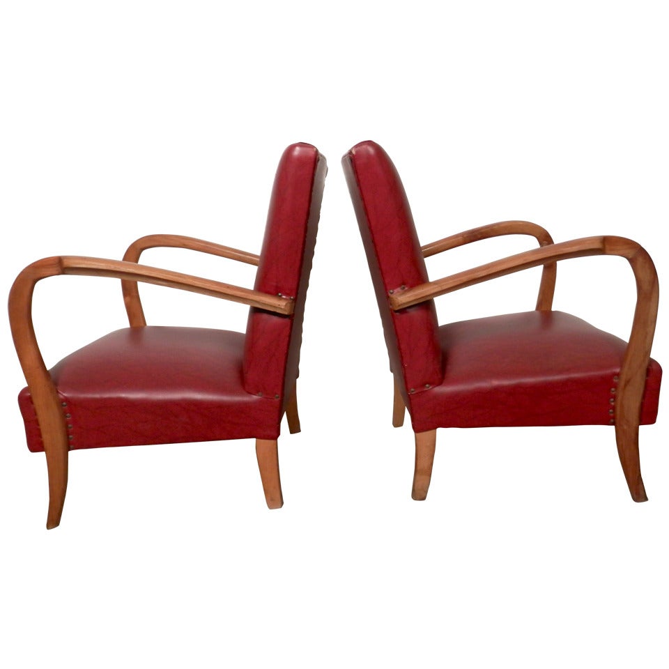 Pair of petite chairs with exaggerated sculpted arms and vinyl cushioned seats. Brass nail head beading around the back and legs add to the detail. Great for living room or office.

(Please confirm item location - NY or NJ - with dealer).