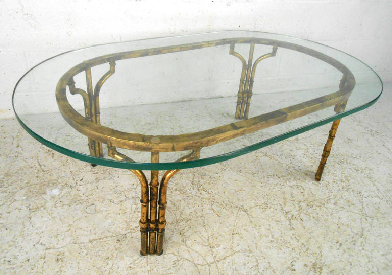 This beautiful contemporary coffee table features a sturdy brushed metal faux bamboo base. Featuring a thick glass top and a vintage feel, this unique cocktail table adds subtle style to any room. Please confirm item location (NY or NJ).
