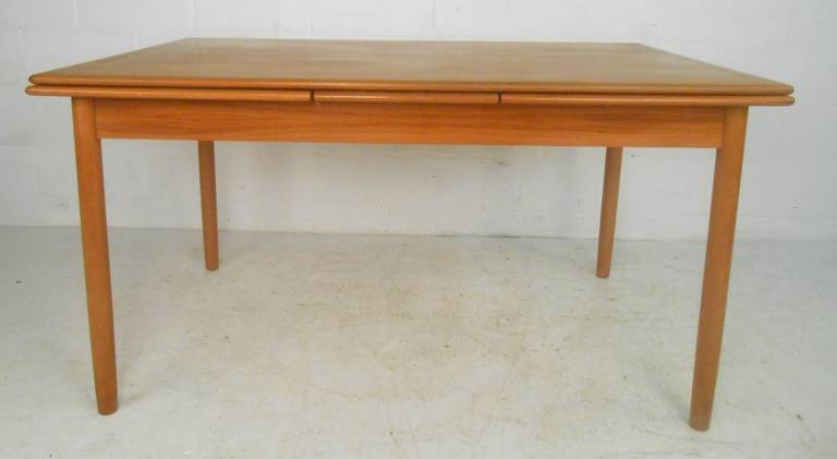 Danish modern draw-leaf dining table in teak makes a versatile and stylish Scandinavian Modern addition to kitchen or dining room setting. Please confirm item location (NY or NJ) with dealer.