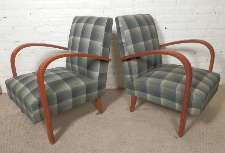 Pair of vintage lounge chairs with dramatic swooping arms in the manner of Thonet. Thick seating, tapered back legs and long, continuous arms and legs.

(Please confirm item location - NY or NJ - with dealer)