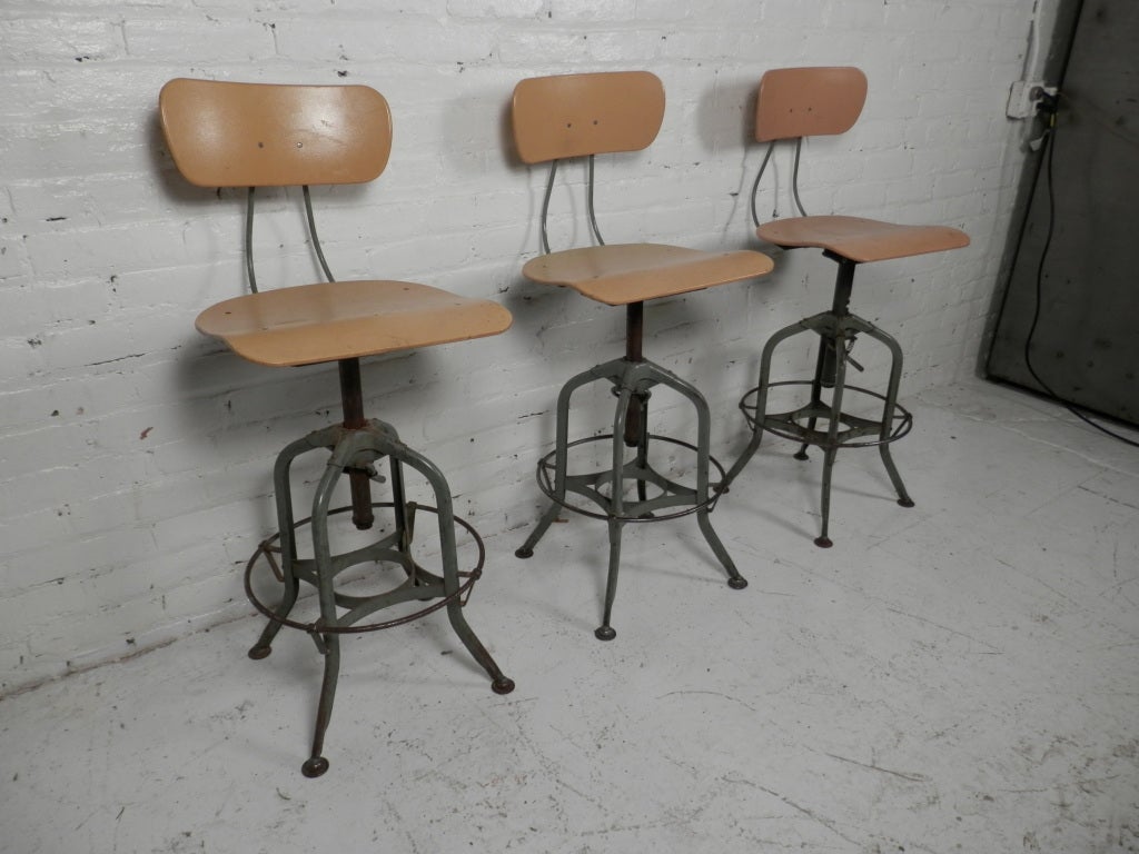Industrial metal drafting stool by the Toledo Furniture Co. Original plastic seat and adjustable back, iron frame with foot rest. Very sought after! Can be sold separately.
Seat height is 22