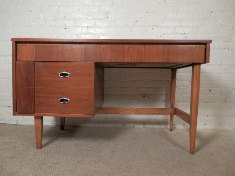 Unusual desk by Hooker with three drawers including "pop out" block on the large file drawer. Attractive walnut grain, nicely accented with metal hardware, tapered legs. A solid and a handsome piece.

(Please confirm item location - NY