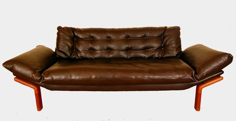 This beautiful tufted sofa by Komfort  Randers Mobelfabrik has been reupholstered in durable faux leather and rests on a classic Danish Teak frame. Extremely comfortable with recently replaced springs, this piece is a perfect addition to any home.