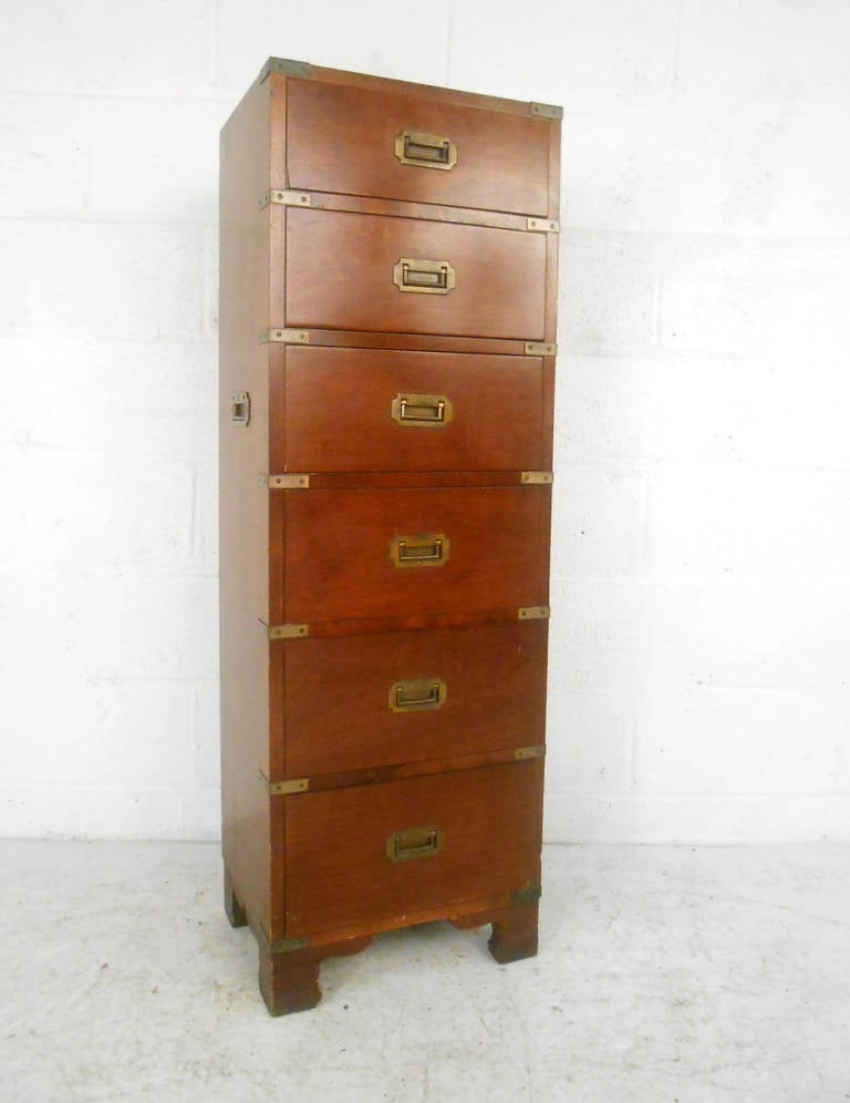 This beautiful chest of drawers features brass accents and pulls, and is a wonderful representation of campaign style design. Unique in it's single file lingerie style arrangement, this stylish storage piece is perfect for rooms with size