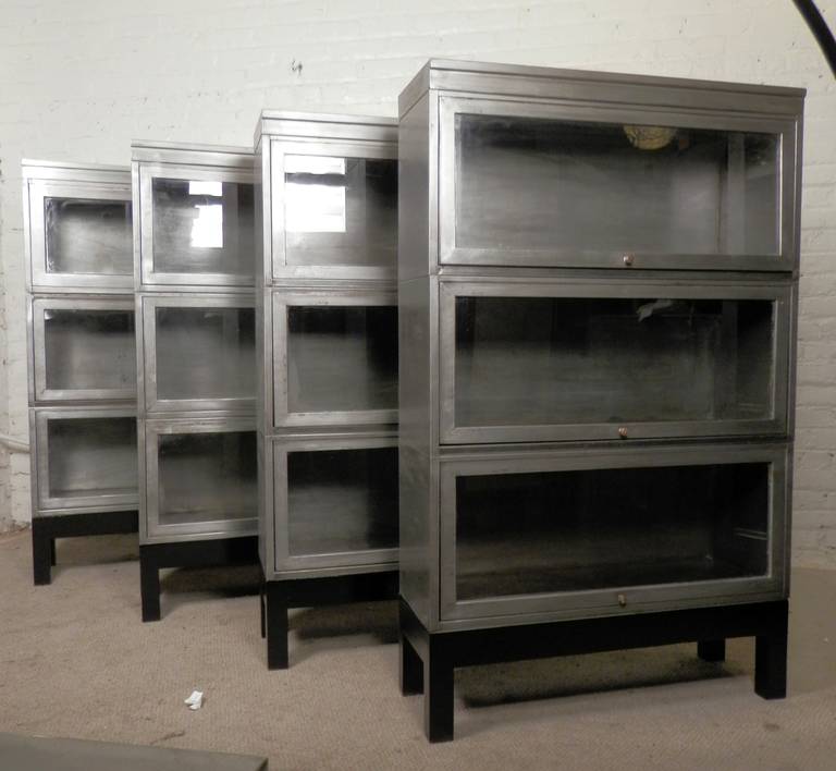 We have a limited set of four barrister metal stack bookcases (listing is for one). Set on black bases with three glass door modular units each. All restored in a bare metal industrial style finish. Get them while they last - (2 left)!

(Please