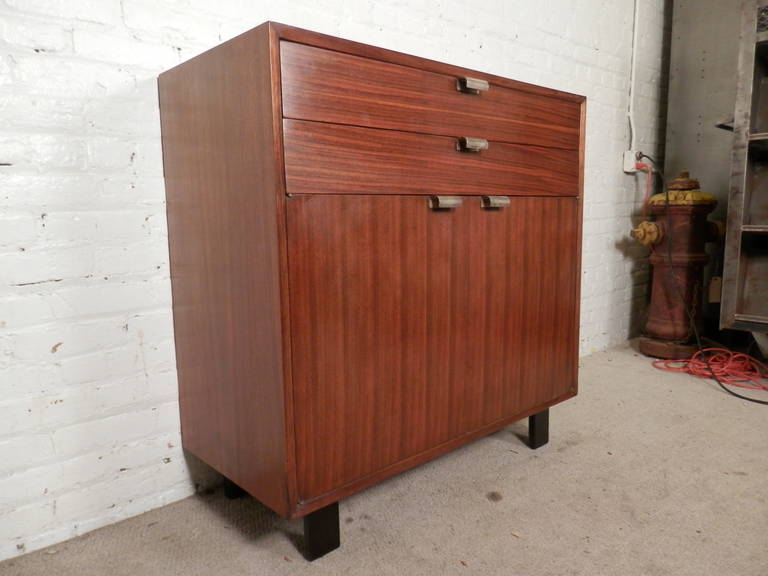 Mid-Century Modern American made walnut cabinet with chrome handles. Designed by George Nelson for Herman Miller with stamp.
Features two cabinet doors revealing one shelf and two drawers one with item divider.

(Please confirm item location - NY