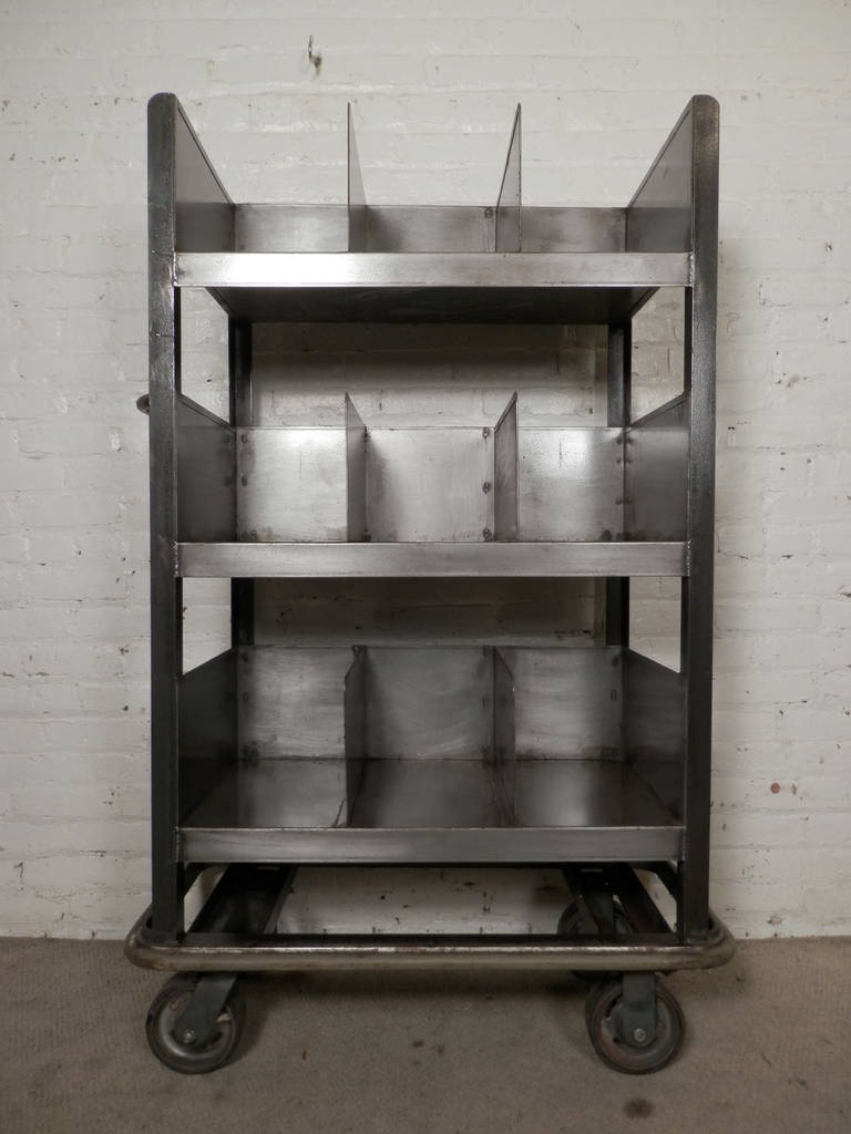 Solidly built Industrial metal storage cart with stripped industrial look. Includes three shelves and a total of nine storage spaces all on large castor wheels. Perfect organization tool for any work shop.

(Please confirm item location - NY or NJ