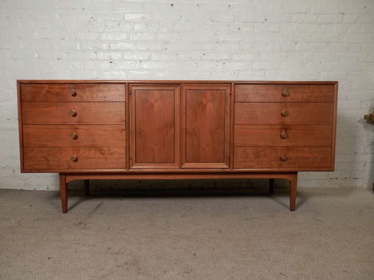 Eleven drawer dresser by Drexel for their Declaration line, designed by Stewart MacDougall and Kipp Stewart. Great walnut grain, clean modern lines, tapered legs, original brass pulls with inlay wood.

(Please confirm item location - NY or NJ -