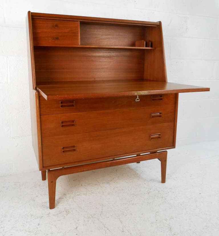 This beautiful teak drop desk makes a great addition to any home or office looking to maximize both floor and workspace. With three drawers for plenty of storage, and wonderfully crafted legs and drawer pulls this piece is a great find. Please