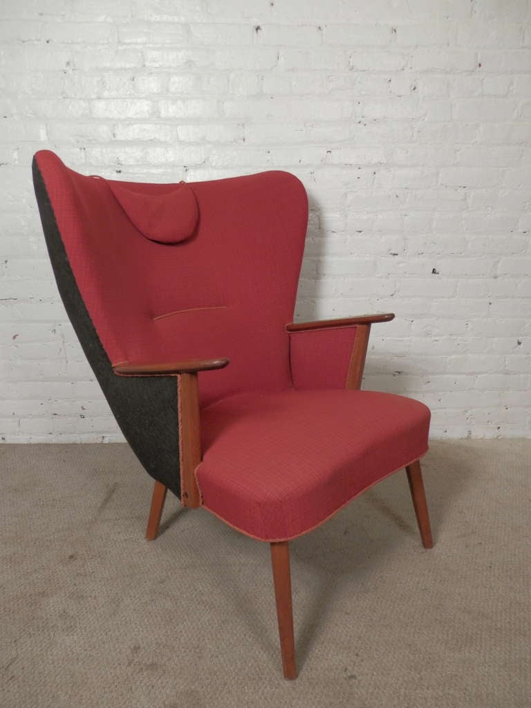 A great example of mid-century modern design with exaggerated lines, large curved wing back, sleek tapered legs. A close likeness to Wegner's famous 'Mama Bear' arm chair, a 'hers' version of the ubiquitous Papa Bear Chair. 

(Please confirm item