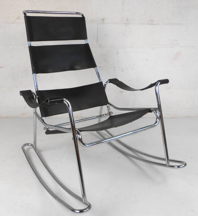 This Italian mid-century rocking chair features wide leather straps framed on a sleek chrome frame. With a unique high back design and wide rocker base, this comfortable and sturdy vintage rocker makes a beautiful addition to any room. Please