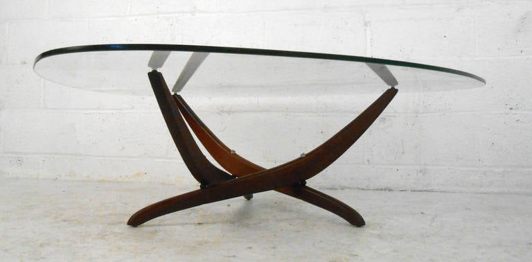 This sculpted base Kagan style coffee table is an elegant mix of glass and hardwood. Unique construction and ample surface space this piece makes a striking mid-century addition to any room, wonderful triangular shaped glass47. Please confirm item