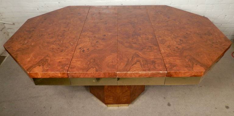 Mid-Century Modern two-leaf table with a fantastic burl wood grain finish. Unique hexagon shape with two extra leaves and brass trimming.

(Please confirm item location - NY or NJ - with dealer).