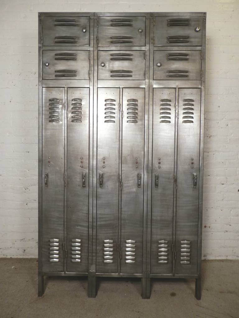 Large one-piece vintage locker unit with considerable storage. Six tall lockers and six accompanying top cabinets. Complete with air slats, coat hooks and original lift-lock handles. Straight from your high school and into your modern