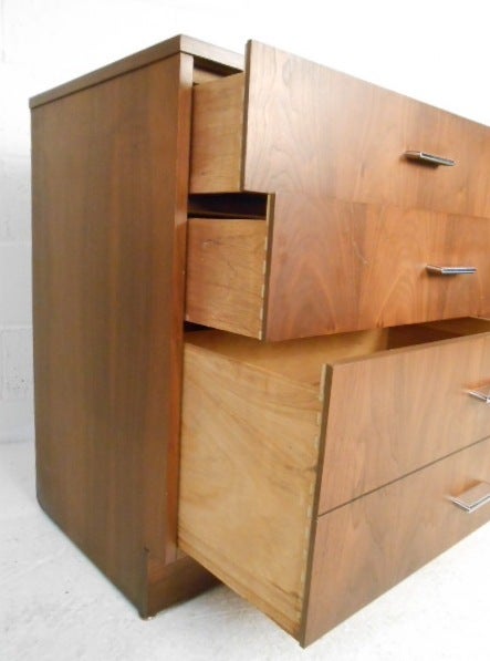 This stylish pair of matching bedroom dressers feature rich walnut finish and stylish chrome pulls. Dovetail jointed drawers provide spacious storage options. This pair makes an ideal addition to any modern bedroom's interior. Please confirm item