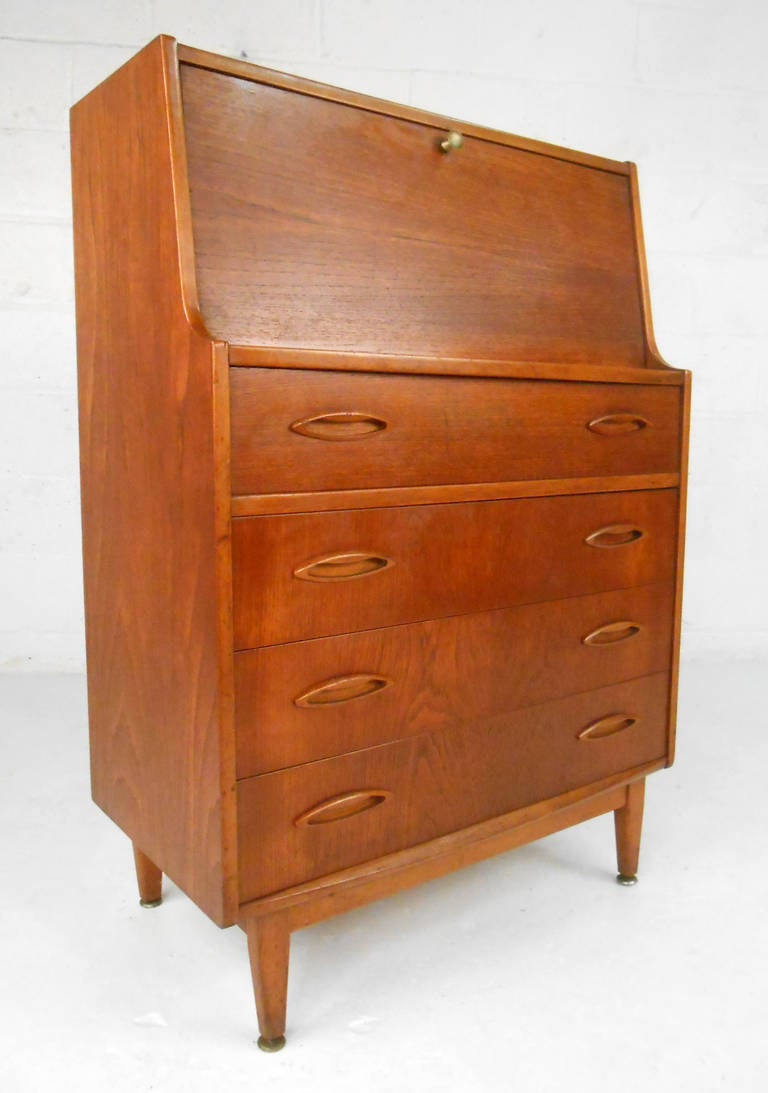 This mixed teak, mahogany, and oak drop front secretary features classic Danish design. Unique surfboard style drawer pulls, a well organized interior desk area, and a uniquely small footprint make this piece a wonderful mix of versatile storage