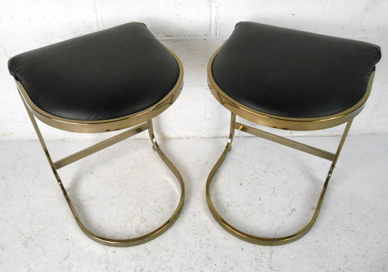 This pair of unique cantilever stools features a wonderful brass colored finish, creating an elegant look for home or business. Perfect solution for occasional seating, their stylized design makes these a great choice for a variety of applications.