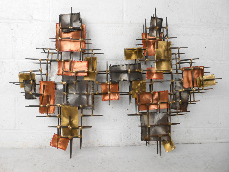 This unique vintage wall art is a wonderful mix of color and mid-century design. Quality welding holds this mixed media metalwork sculpture together, and includes sturdy wall hanging hooks. Please confirm item location (NY or NJ).