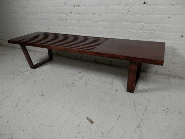 Classic slat bench by mid-century modern designer George Nelson for Herman Miller. Slat style with one solid top section. Makes a great bench or coffee table.