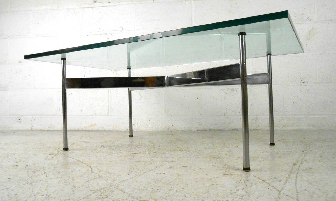 This beautiful 1960s chrome and glass coffee table by Katavalos, Litell, and Kelly for Laverne International. This exquisite piece features thick glass top and seamlessly manufactured X-style base. Carefully designed with stoppers to keep both glass