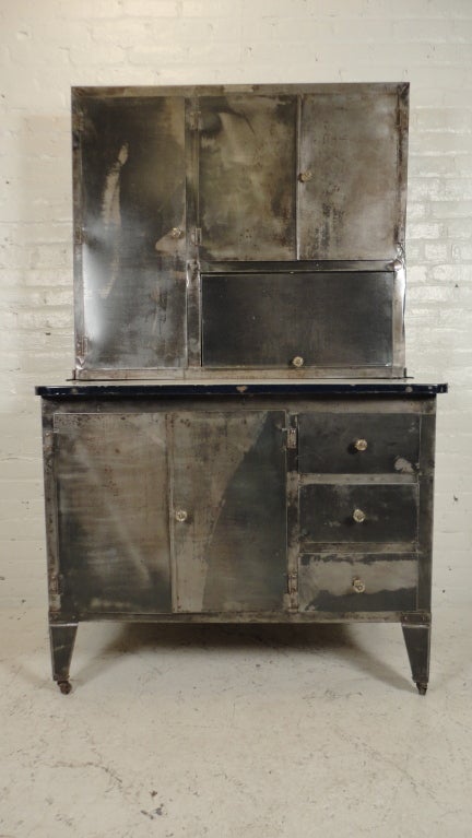 Bare metal Hoosier cabinet with glass pulls & porcelain counter top.
