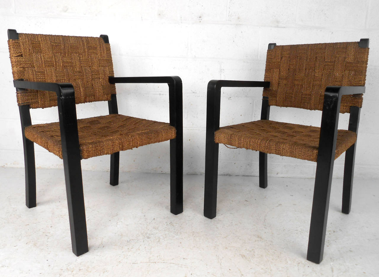 This vintage pair of intricately woven rope chairs make a perfect set of seats for any room. Sturdy black lacquered frames complement unique rope back and seat. Comfortable and unique, please confirm item location (NY or NJ).