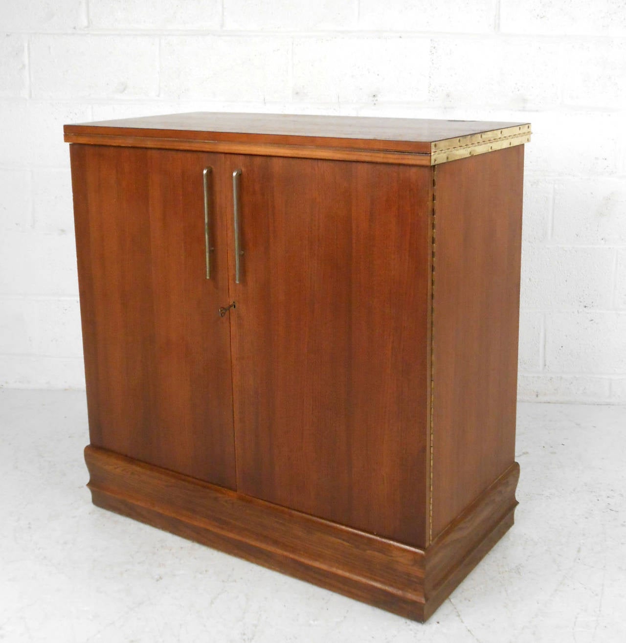 This rolling vintage dry bar was designed by early 1900's designer and inventory Henry P Glass. A former employee of Russel Wright, he was well known for his work in architecture and design. The top piece opens up to reveal a specially coated