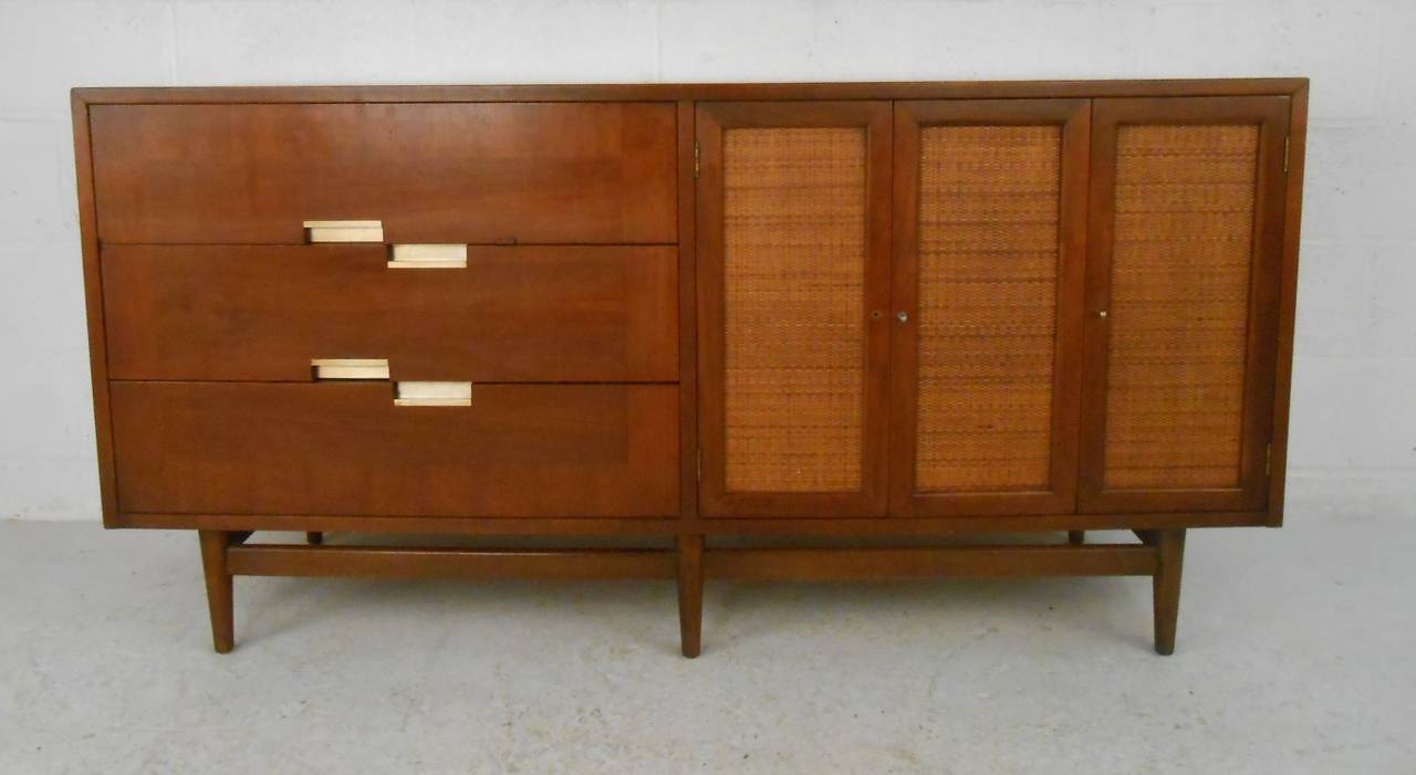 Nicely detailed American of Martinsville walnut credenza featuring caned doors, brushed aluminium drawer pulls and decorative aluminium inlays on top. Please confirm item location (NY or NJ) with dealer.