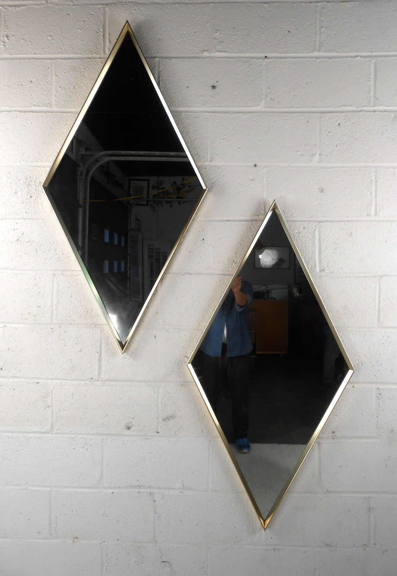 This large matching pair of diamond shaped wall mirrors make a wonderful addition to any midcentury decor. Brushed metal frames and sturdy fixtures for hanging make these a quality example of classic midcentury design. Please confirm item location