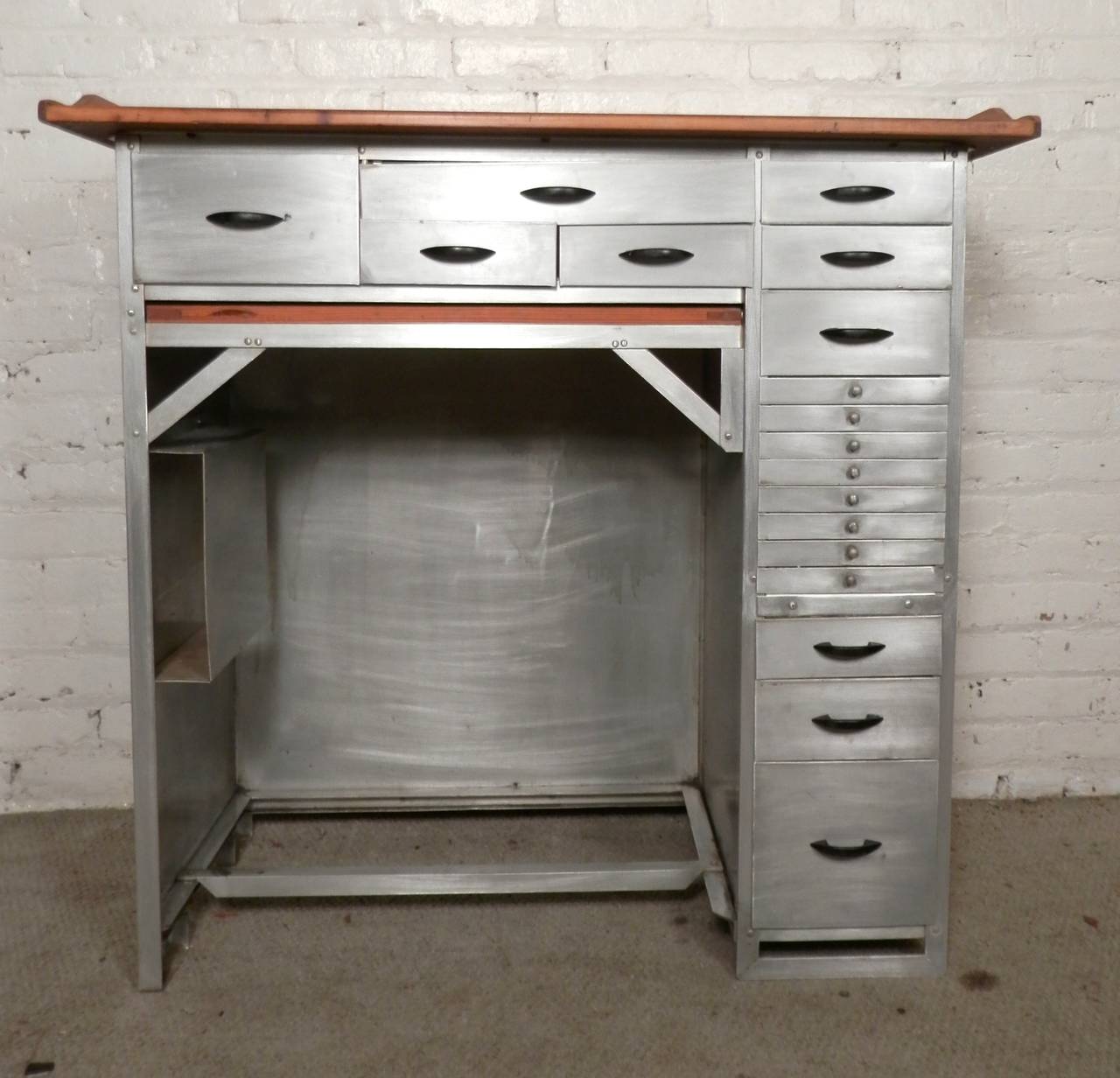 Impressive metal desk with numerous drawers used originally for watch making. Finished wood top, bare metal style finish, original black handles. Makes a great kitchen prep table as well as office desk.
Kneehole: 23w 16d 28h

(Please confirm item