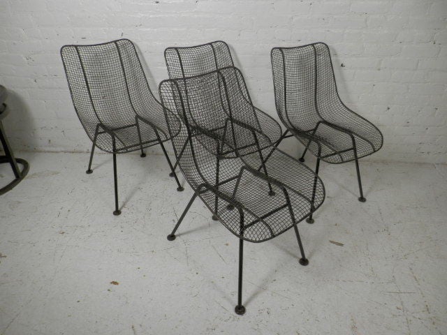 Classic Russell Woodard design. Mesh iron chairs with sculpted shape. Woodard chairs have become synonymous with casual outdoor furniture.