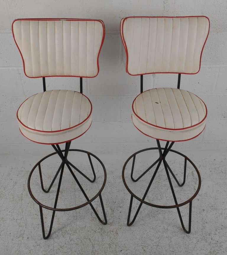 Pair of Frederic Weinberg swivel bar stools with black rod hairpin legs and round footrest ring (three more available). Six Available. Please confirm item location (NY or NJ) with dealer.