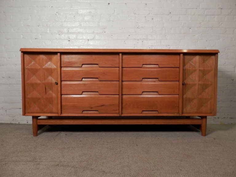 Mid-century modern eight drawer dresser with sculpted front side cabinets. Nice brass detailing and hardware, plenty of storage. Used in bedroom or living room. Well designed by Salvatore Bevelacqua for Alliance Furniture Co.

(Please confirm item