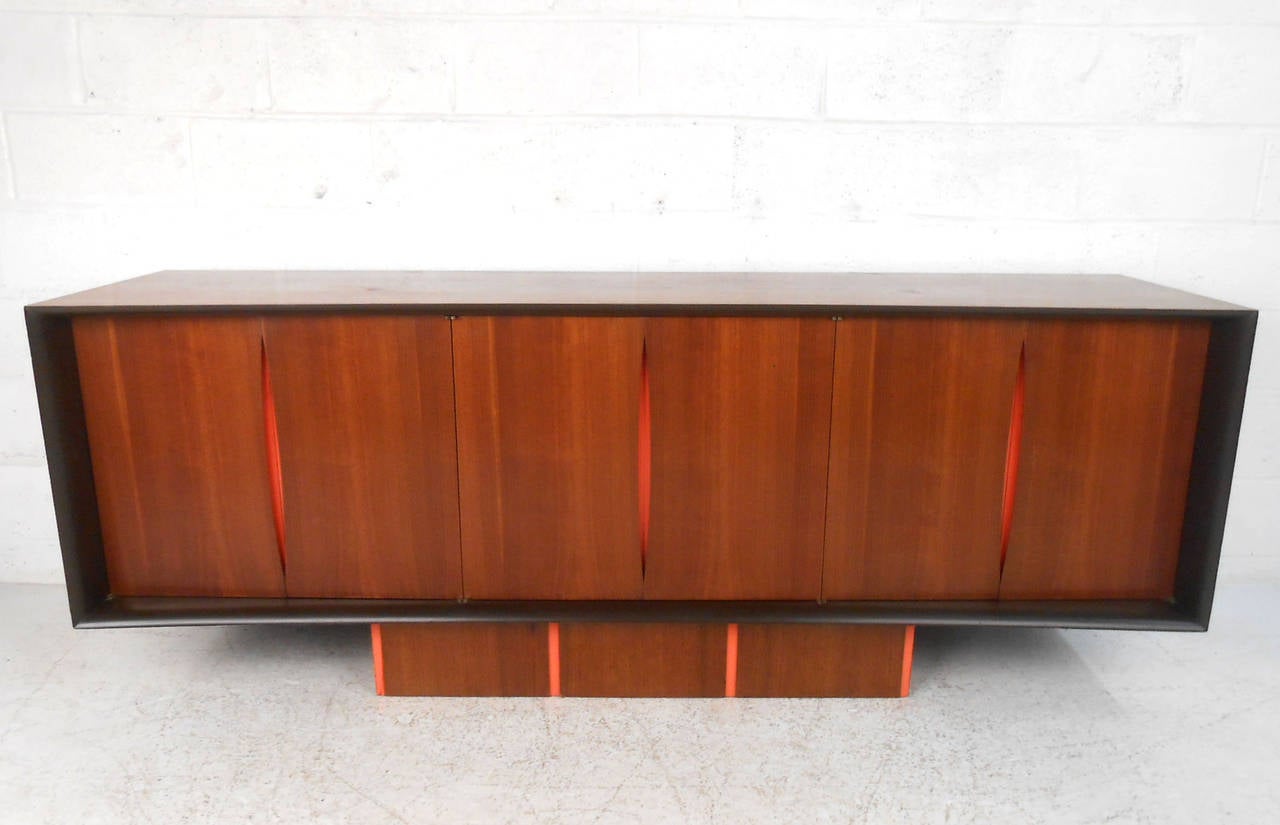 This designed sideboard combines incredible Mid-Century style with a wonderful assortment of storage options. Wonderfully constructed sculptural cabinet features gorgeous wood grain mixed with its bright accent color. A wide array of storage and