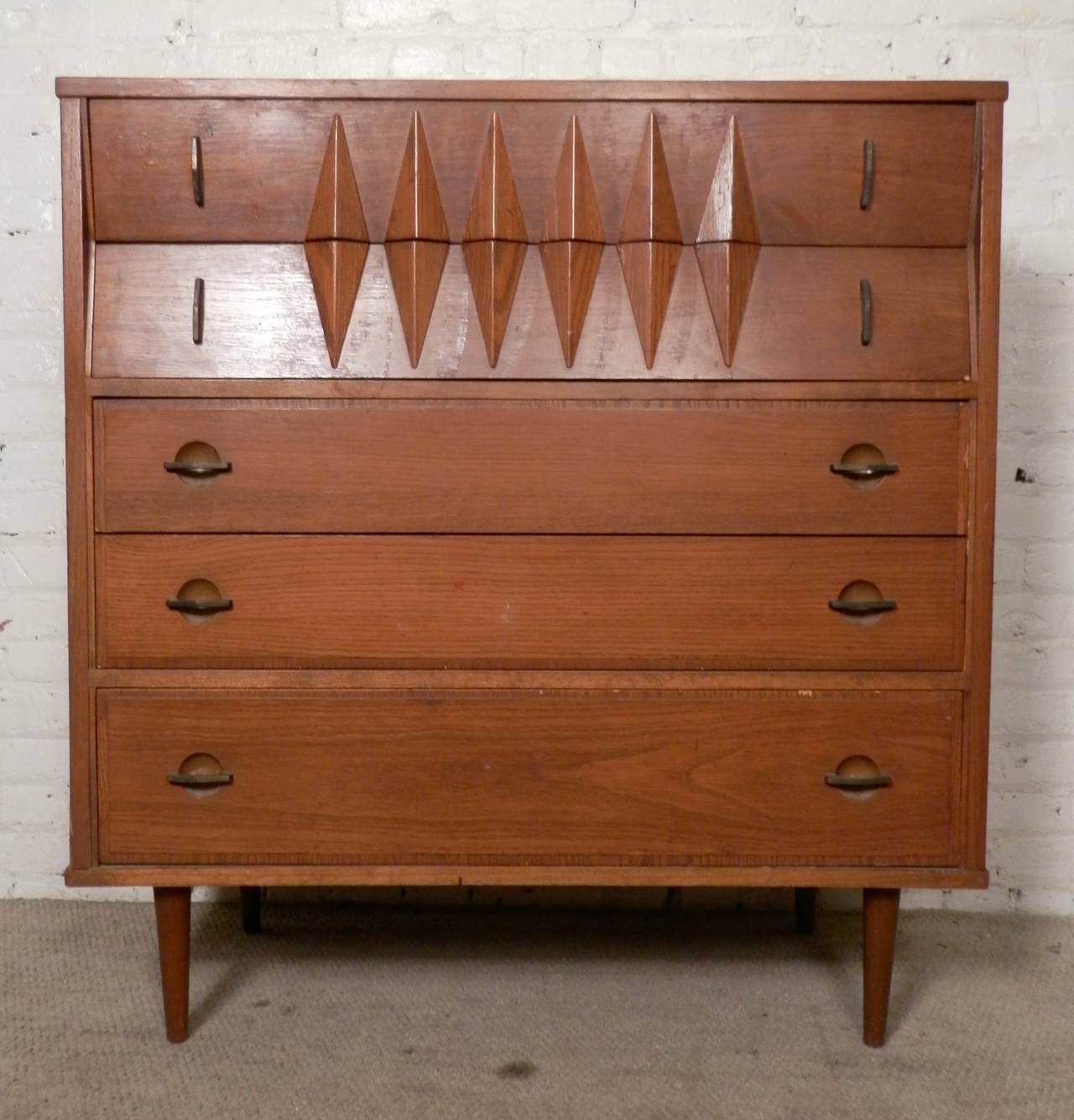 Vintage modern American dresser with a sculpted diamond style front, brass detailing, laminate top and cone-shaped legs. Unusual design that stills works in modern rooms.

(Please confirm item location - NY or NJ - with dealer)