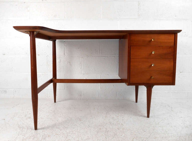 Featuring beautiful tapered legs, unique drawer pulls, and a finished back this lovely writing desk makes the perfect addition to mid-century home or office. Please confirm item location (NY or NJ).