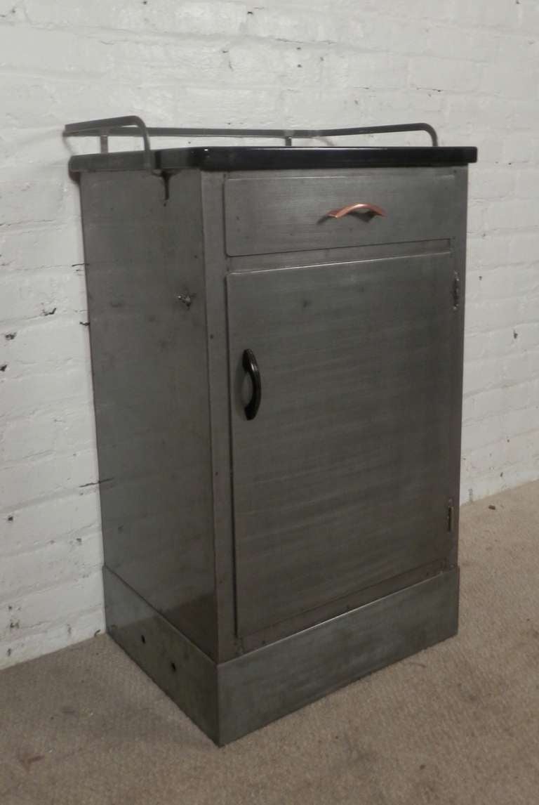 Industrial metal cabinet with sliding drawer and open cabinet. Porcelain black top, accenting copper handle, newly striped and lacquered for a handsome industrial look.

(Please confirm item location - NY or NJ - with dealer)
