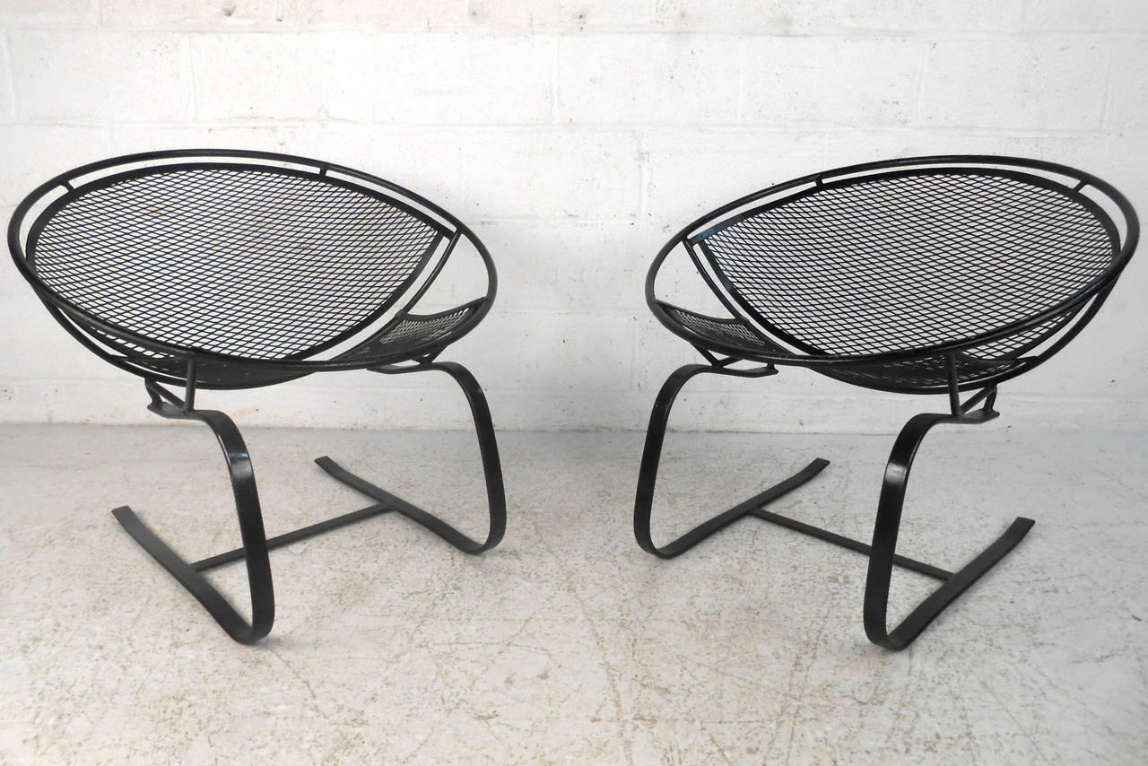 Pair of vintage modern designer patio chairs by Maurizio Tempestini. Iron clamshell style shape are very distinctive and desired. The cantilevered spring legs allow a gentle rock or bounce while seated. Please confirm item location (NY or NJ).