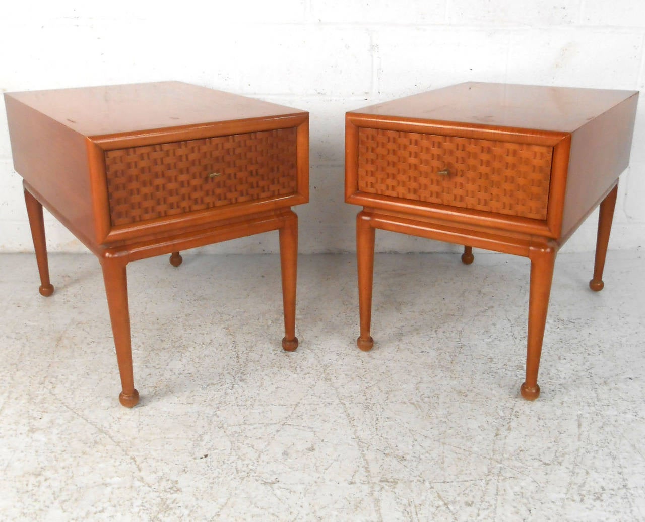 This pair of midcentury end tables are uniquely sized with extra deep drawers for storage, drumstick legs, and vintage basket weave style drawer fronts. Please confirm item location (NY or NJ).