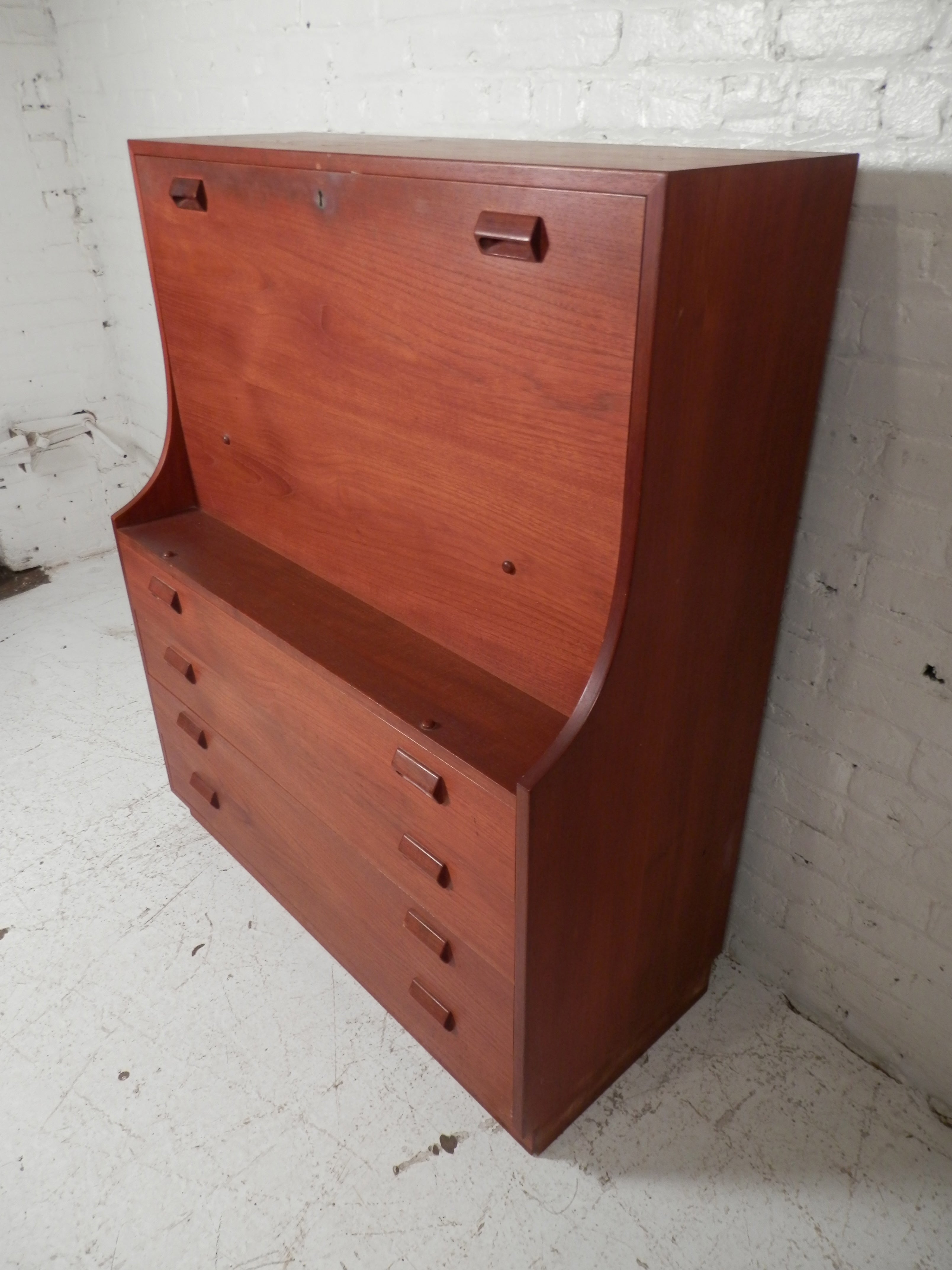 Vintage Danish modern secretary desk. Fold down table with office storage and four dresser drawers. Classic Danish modern design with wood handles and beautiful teak wood grain.