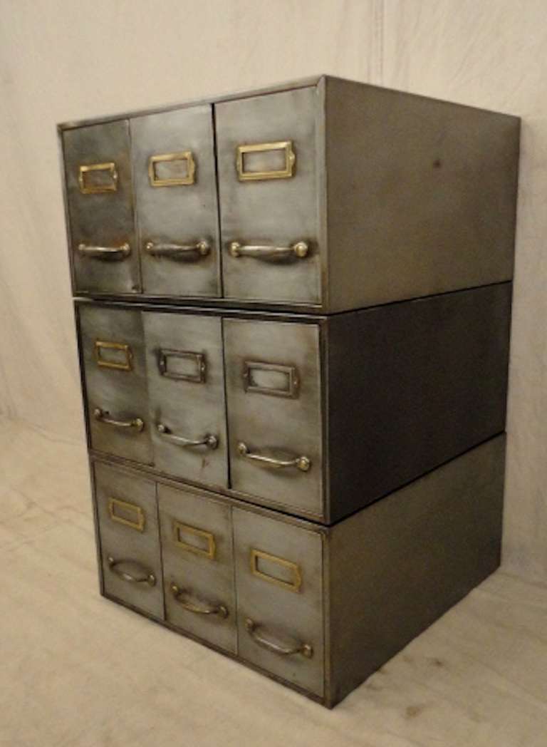 Vintage industrial metal nine drawer file cabinet. Each level stacks, nice brass accenting card holders, striped to a nice bare metal finish.

Each drawer measures 6w 21d 7h.

(Please confirm item location - NY or NJ - with dealer)