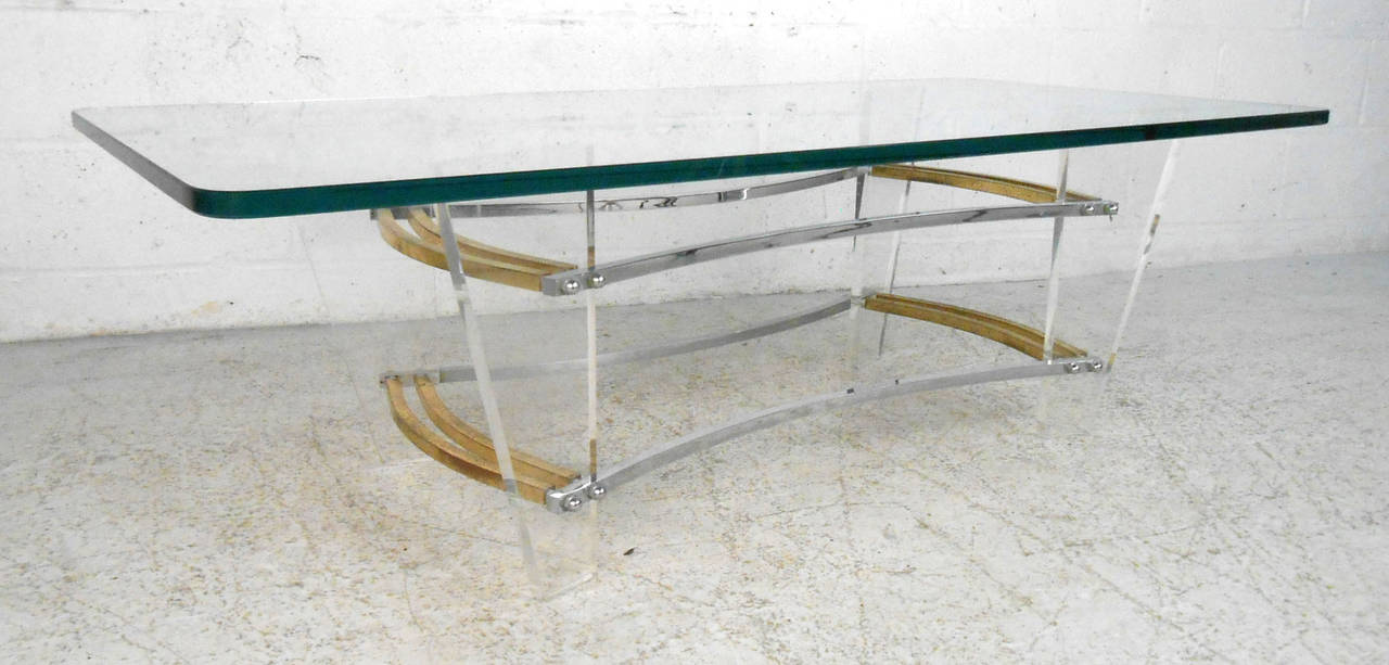 This beautiful lucite and brass cocktail table adds subtle modern style to any room. Sturdy base and thick glass top make this suitable for regular use, please confirm item location (NY or NJ).