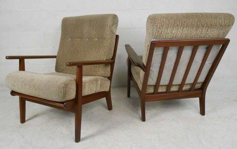 Stylish Hans Wegner style pair of GETAMA lounge chairs by Aage Pedersen make a great pair of chairs for any setting. The high-back Danish lounge chairs feature thick upholstered cushions and rosewood frames. (Please confirm item location - NY or NJ