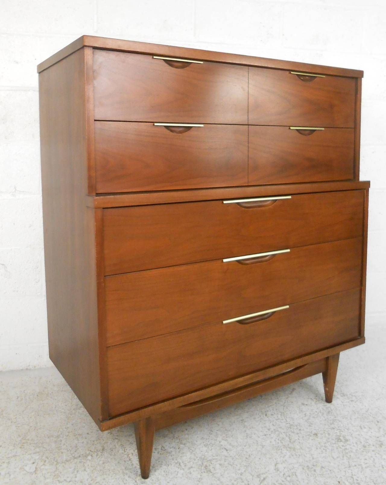 This beautiful mid-century highboy features the stunning design manufacturer Kent Coffey was so well known for. This piece for the Tableau furniture line features inlaid metal drawer pulls, sturdy hardwood construction, and stylish tapered legs.