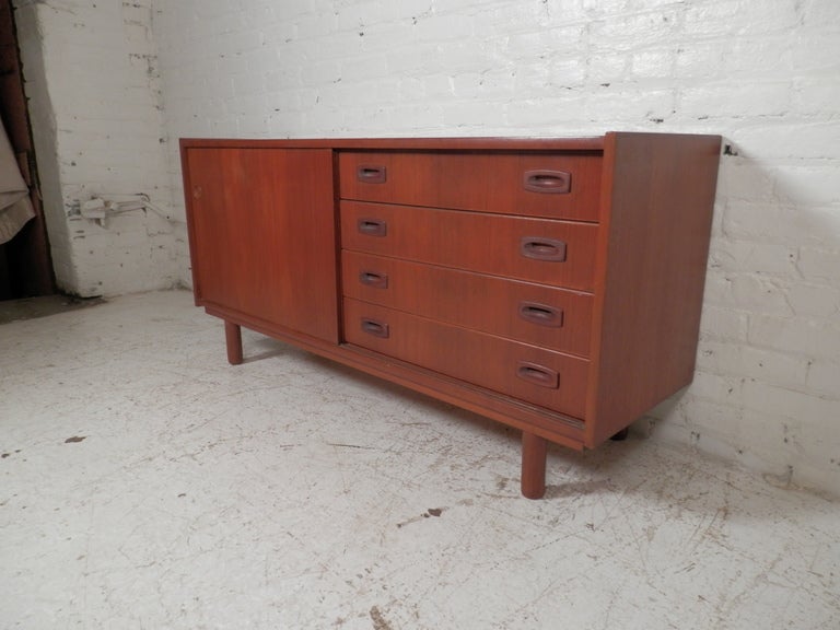 Newly re-finished Danish cabinet. Sliding door cabinet with spot for adjustable shelf, and four drawers on right side. Classic Danish modern design with beautiful teak grain.

(Please confirm item location - NY or NJ - with dealer)