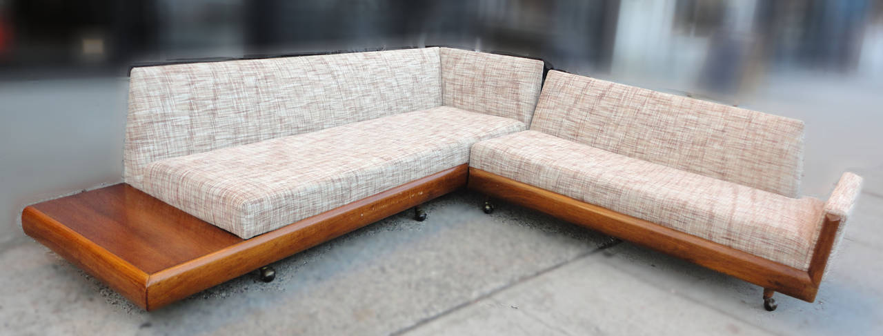 Gorgeous Adrian Pearsall sectional sofa with attractive wood trim. This has great Mid-Century lines, rolling casters, and a warm walnut side shelf attached. The sofa is two separate parts that aline to make an L-shape set.

Sofa measures: 67