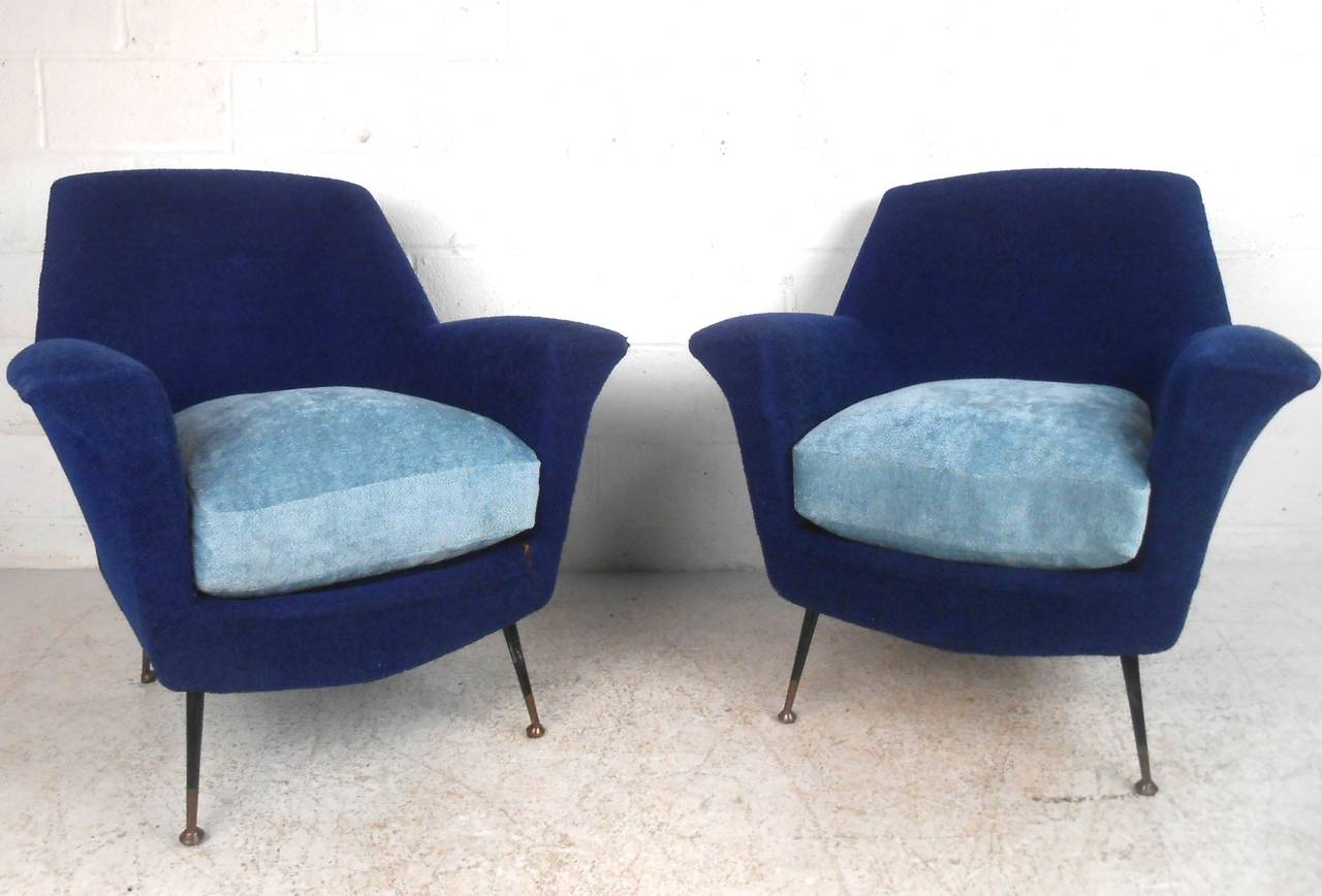 This pair of Mid-Century modern lounge chairs features the unique design style of Gio Ponti. Two-tone upholstery and curved back and armrests make these a stylish and comfortable selection for any room. Please confirm item location (NY or NJ).